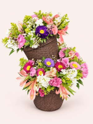 Arreglo floral Caricia Floral con flores rosas, blancas y moradas en bases oscuras