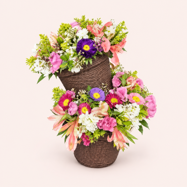 Caricia Floral Arreglo floral Caricia Floral con flores rosas, blancas y moradas en bases oscuras